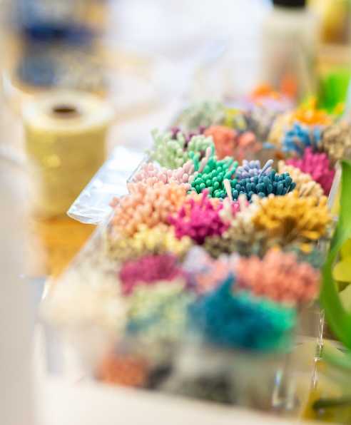 Une photo colorée et floue de matériel de loisirs créatifs comme une boîte de pompoms